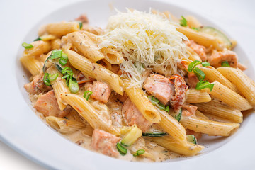 penne pasta bolognese with parmesan, served on white plate