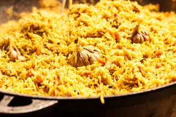 Fresh appetizing pilaf. Cooked with fried lamb, rice, garlic, carrots in a large caviar.