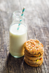 Sweet cookies with colorful candies and milk.