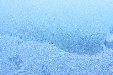 Frozen winter abstract background with a pattern on the window glass