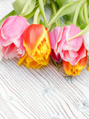 Fototapeta na wymiar A bouquet of freshly cut multicolored tulips on an old wooden table. Copy space