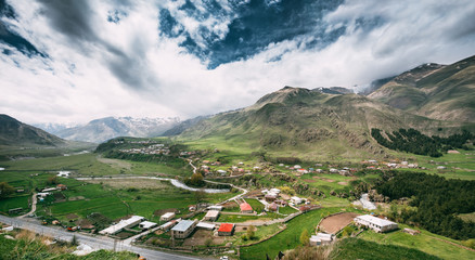Fototapeta na wymiar Tkarsheti Village On Mountain Background In Kazbegi District,