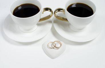 Two cups of coffee and wedding rings. Valentine's Day. Wedding