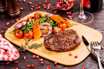 steakhouse porterhouse steak and colorful fresh roast vegetables  on a wooden board, view from above