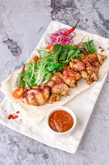 top view delicious Bbq meat with vegetables, sauce spices chile on gray concrete background. with ketchup on white plate, view from above