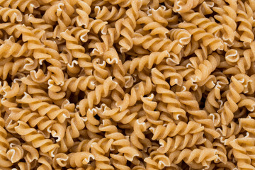 Uncooked wholemeal pasta isolated white background.