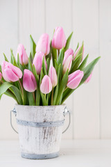 Fototapeta na wymiar Spring easter tulips in bucket on white vintage background.