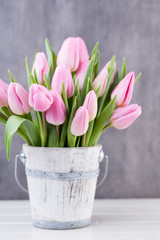 Spring easter tulips in bucket on white vintage background.