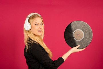 Fototapeta premium Beautiful young woman holding a vinyl in her hands as she listens to the music