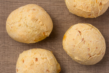 Pao de Queijo is a cheese bread ball from Brazil. Also known as Chipa, Pandebono and Pan de Yuca. Snacks on wood table, flat lay design.