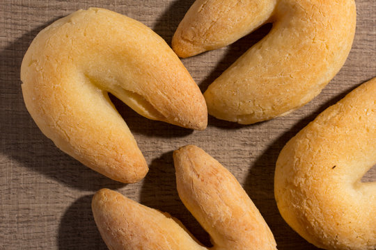 Cheese bread known as Chipa in Brazil, shaped like a horseshoe. Snacks on wood table, flat lay design.