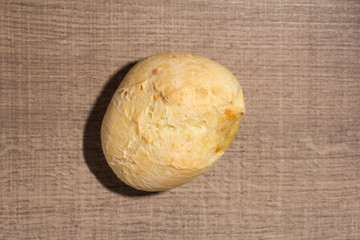 Pao de Queijo is a cheese bread ball from Brazil. Also known as Chipa, Pandebono and Pan de Yuca. Snack on wood table, flat design.