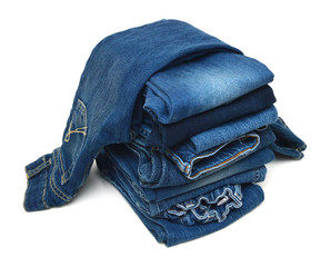 Stack of blue jeans a white background