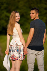 Active young couple on a wlak in the park on hot summer afternoon
