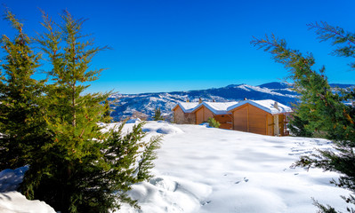 Winter landscape with snow, wooden houses and clear blue sky, Trikala Korinthias, Greece.