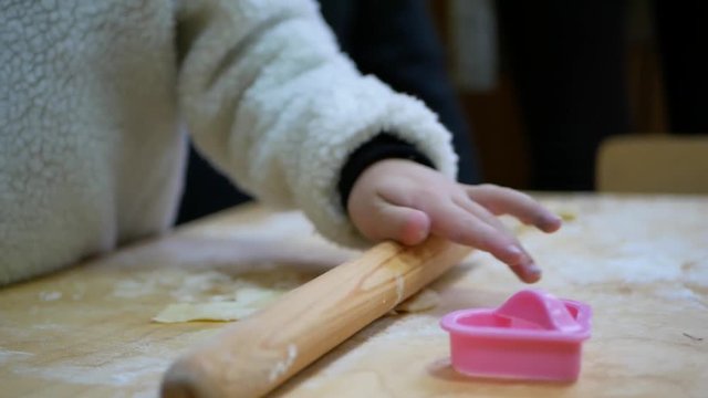 Small hands kneading dough. Little child preparing dough for backing