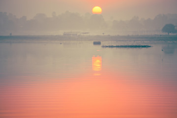 Selective focus on the sun during the sunset on the lake