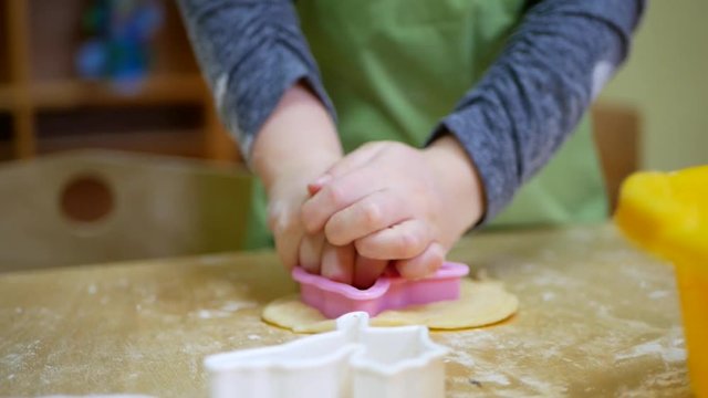 Small hands kneading dough. Little child preparing dough for backing