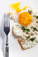 Natural fried egg with a sprouting yolk and fork