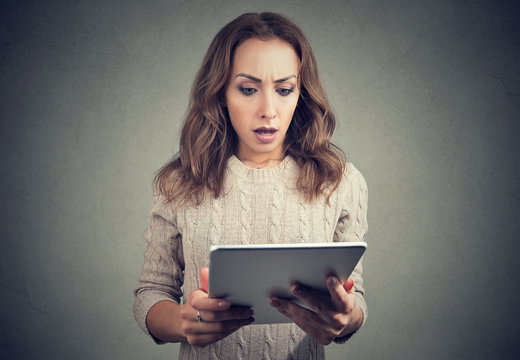 Terrified young woman watching tablet