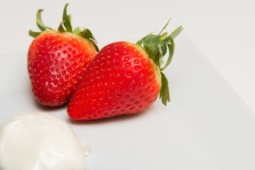 Fresh ripe Strawberries and cream isolated on a white table background