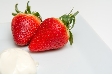 Fresh ripe Strawberries and cream isolated on a white table background
