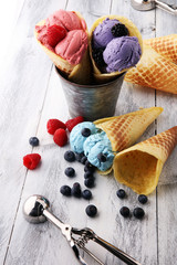 Set of ice cream scoops of different colors and flavours with blueberries, raspberries and blackberries.