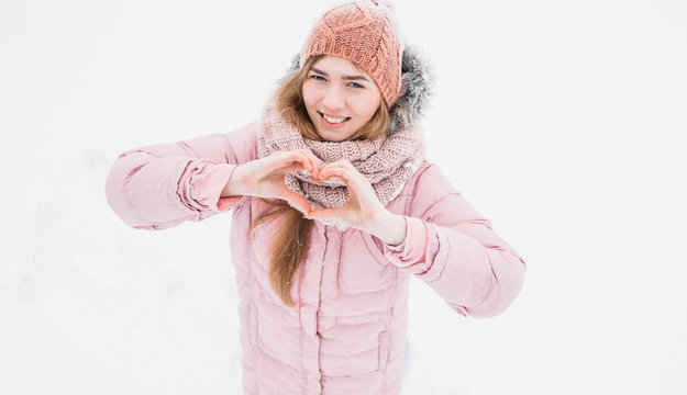 A young girl shows a heart with your hands, winter's morning, Valentine's Day, happy beautiful, the picture for reklamy,