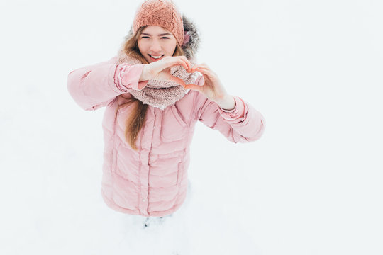 A young girl shows a heart with your hands, winter's morning, Valentine's Day, happy beautiful, the picture for reklamy,