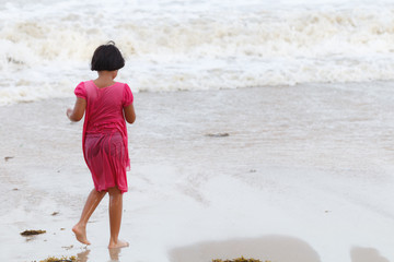 Fototapeta na wymiar Asian girl playing on the beach