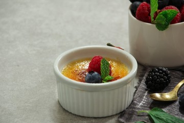 Homemade  Classic Creme Brulee with burnt sugar berry topping, selective focus
