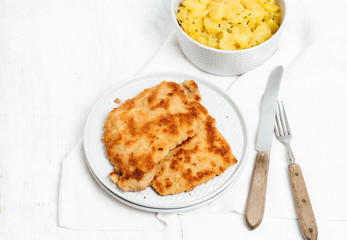 Traditional German or Austrian Wiener Schnitzel or Schnitzel Wiener Art, breaded and pan-fried butterfly cutlet of pork, veal of chicken meat served with homemade potato salad