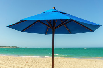 blue sun umbrella on the sandy beach