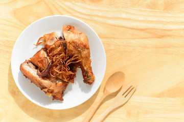 Fried chicken leg with fried onion on top ready for eating