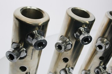 Upper front view on large diameter electric cable connection tubes with allen key screws, made of stainless steel, looking like some strange wind musical instrument