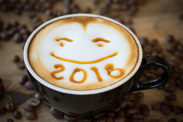 Top view white cup of latte art happy smile face on brown wooden table background