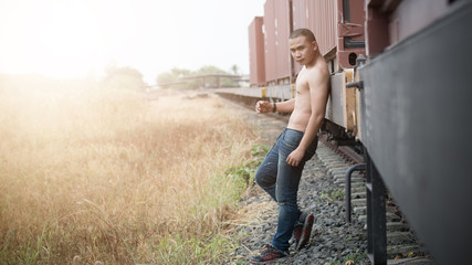 Asian shirtless male model at railroad