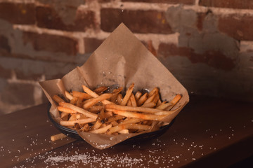Crispy French Fries in a Basket with Sprinkled Salt