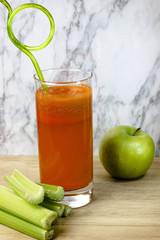 Fresh, healthy, homemade carrot juice in a glass with carrots, apple and celery stalks, Vegetable juice.
