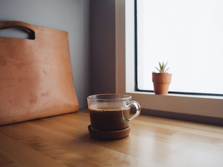 Hot coffee cup on the table in low light condition by the window. Concept of relax and concentrate.