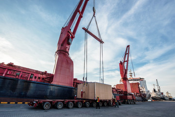 heavy lift cargo handle by professional teamwork to locate package from the ship crane onto the...