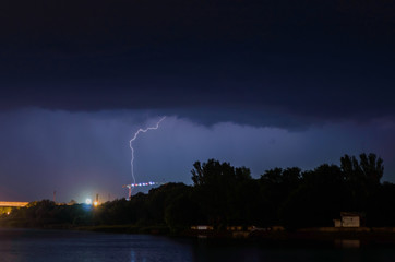 Single lightning in storm, thunderstorm in dark skies