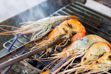River shrimp or river prawn grilled barbecue seafood on charcoal stove. close up on fired food, Thai seafood