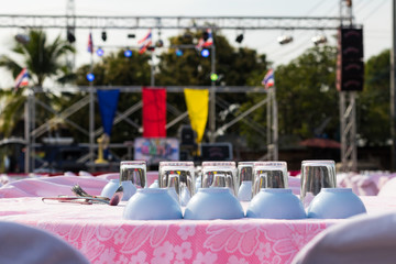 Glasses and cups are placed on the table in front of the stage.