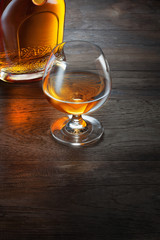 close up view of  glass with cognac  on wooden background