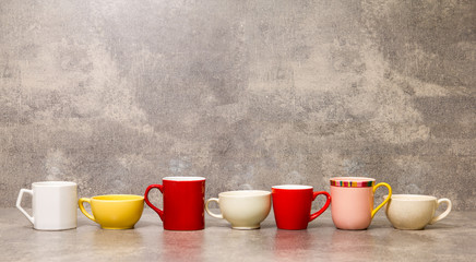colorful cups of coffee on concrete background