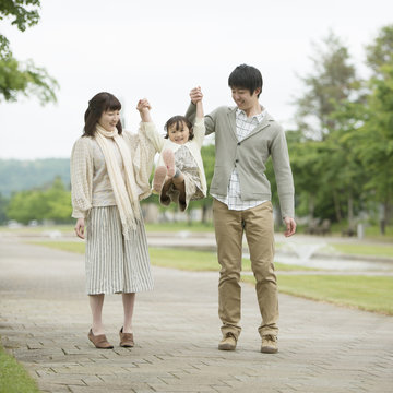 手をつなぎ微笑む親子