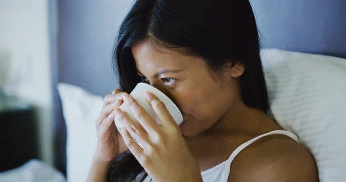 Beautiful mixed race woman enjoying relaxing morning drinking coffee at hotel