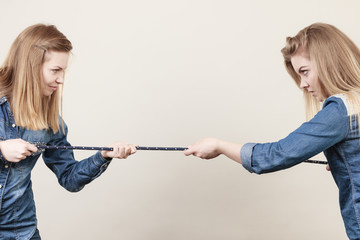 Two women having argue pulling rope