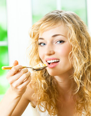 Cheerful woman eating cereal muslin